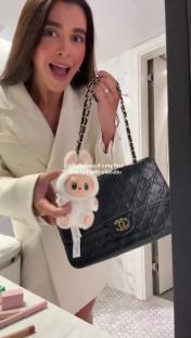 Woman holding a Chanel bag and a fluffy toy.