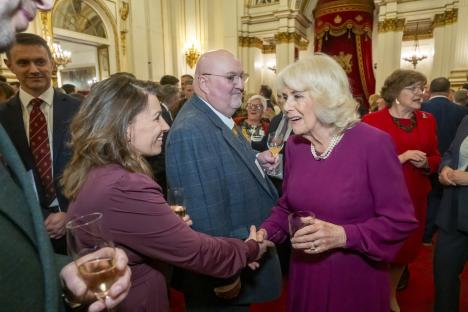 Queen Camilla shaking hands with Gill Smith at Buckingham Palace.