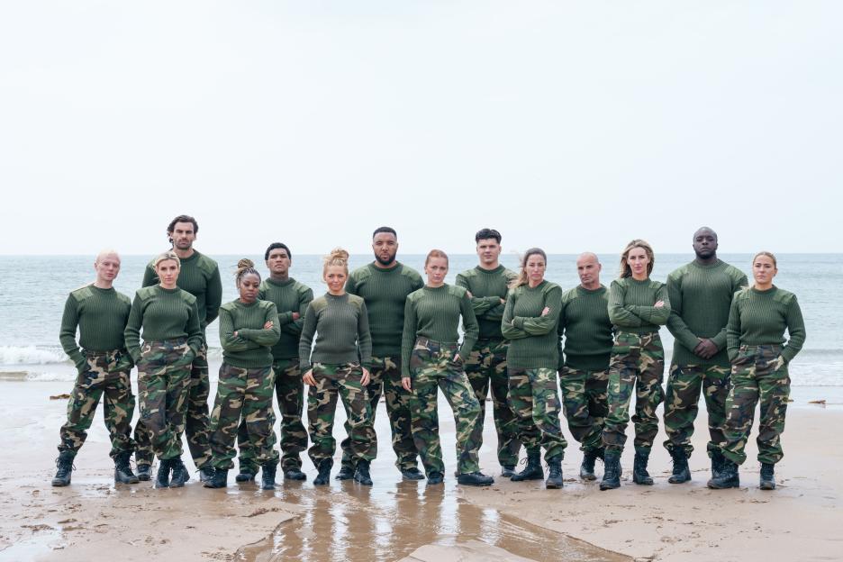 Group of people in camouflage uniforms on a beach.