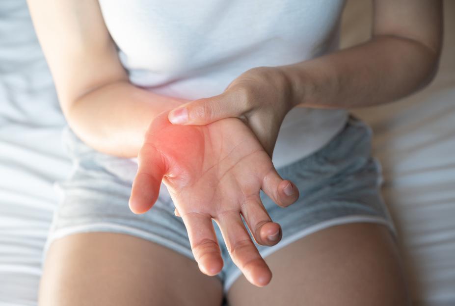 Woman suffering painful sprains or fractures on her hand.