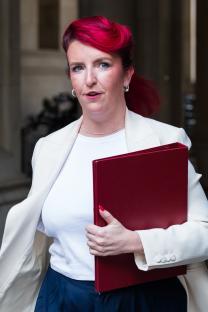 Louise Haigh, Secretary of State for Transport, carrying a red folder.