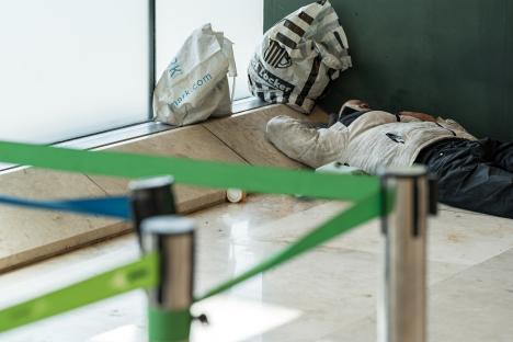 Person sleeping on the floor of an airport terminal.