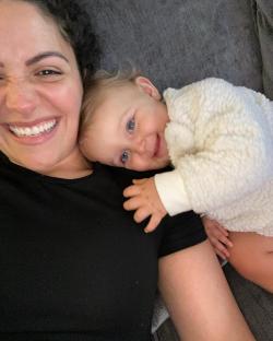 Smiling woman cuddling a baby.