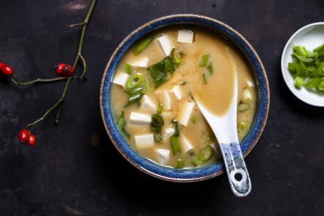 Bowl of miso soup with tofu and scallions.