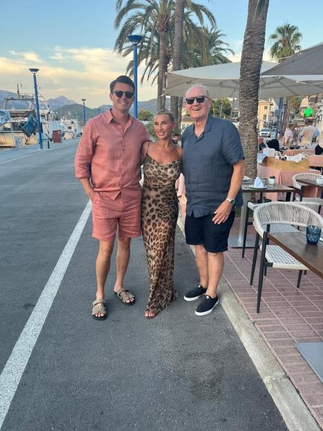 Three people posing for a photo outside a restaurant.