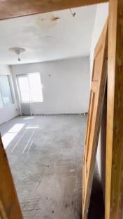 Empty room with concrete floor and a leaning door.