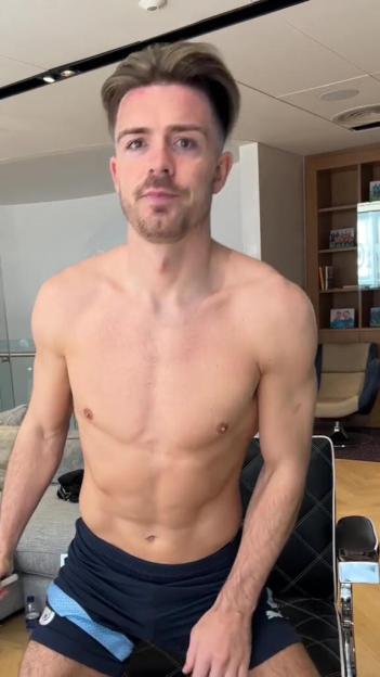Jack Grealish posing shirtless in shorts.