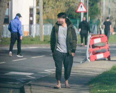 Migrant walking near a fence at RAF Wethersfield.