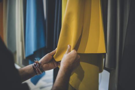 Person inspecting yellow leather sample.
