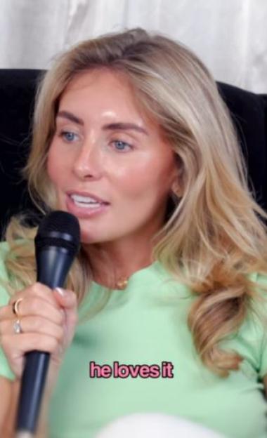 Woman speaking into a microphone; text overlay reads "he loves it."
