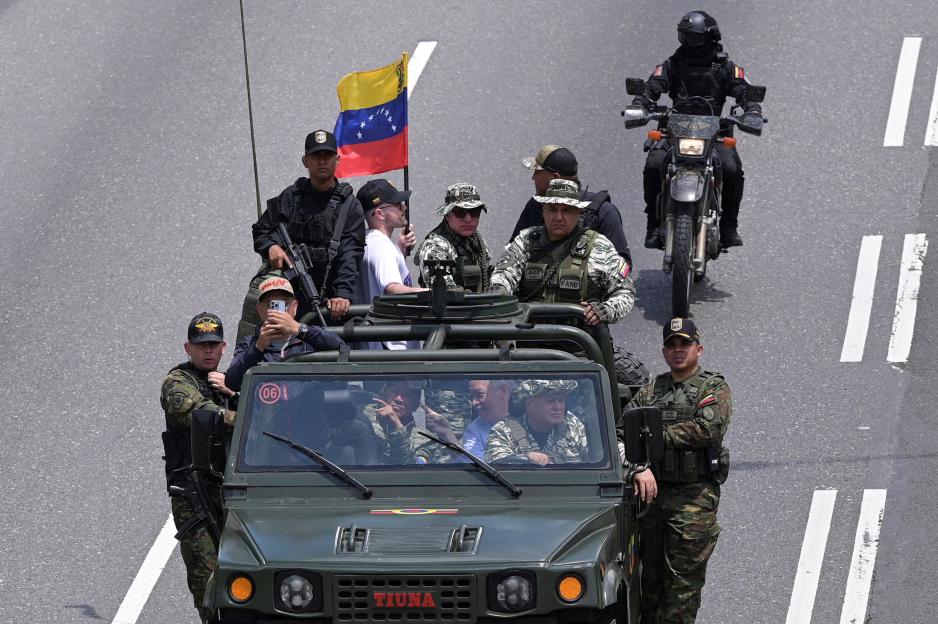 Venezuela's Interior Minister Diosdado Cabello in the driver's seat of a military vehicle, participating in a drill to train citizens in weapons handling.