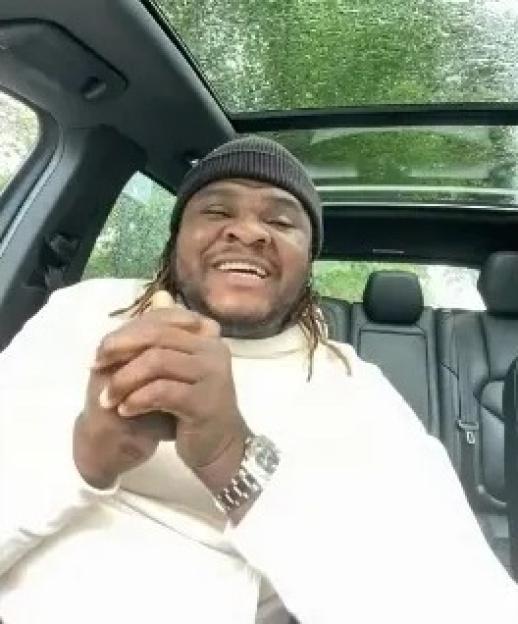 Alexander Isak sitting in a car, smiling and clapping his hands.