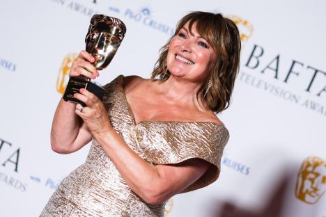 Lorraine Kelly holding a BAFTA award.