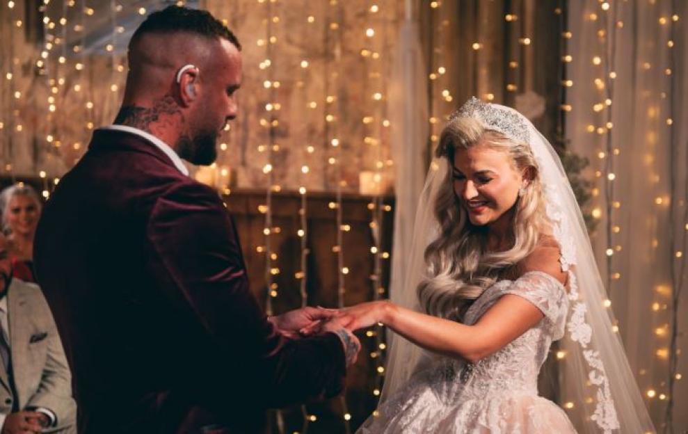 Ross McCarthy and Sacha exchanging rings at their wedding.