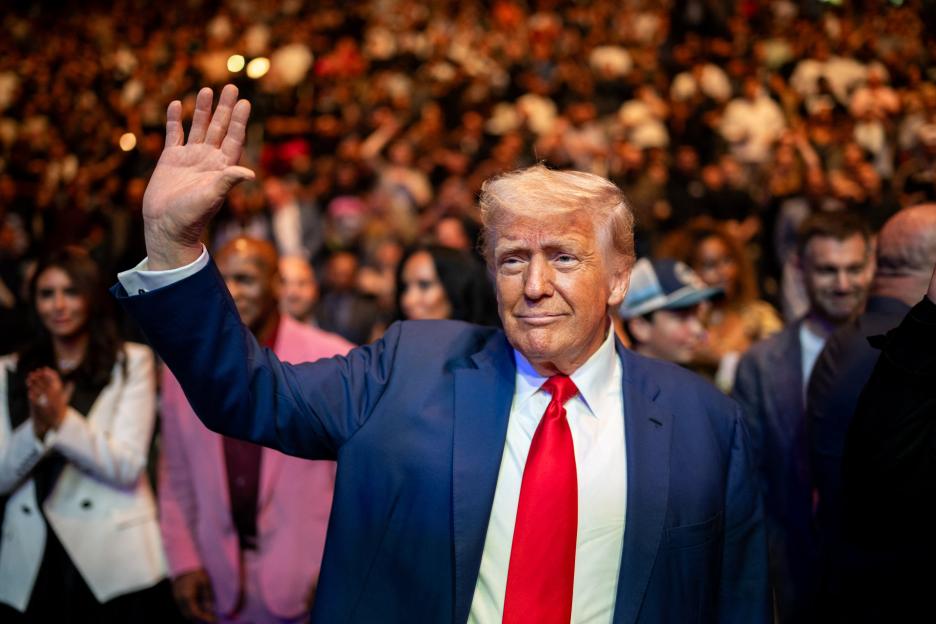 President Donald Trump at a UFC event, waving to the crowd.