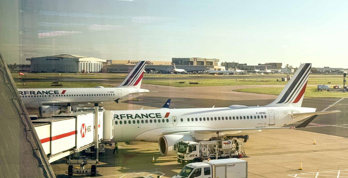 Two Air France planes parked at an airport tarmac, with one connected to a jet bridge.