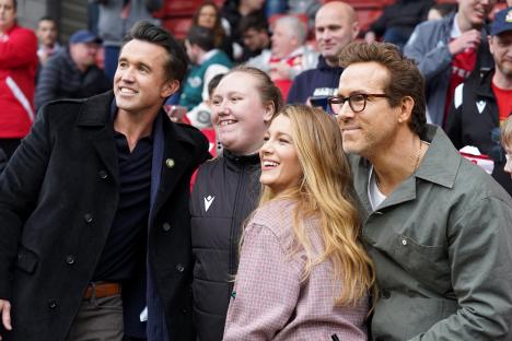 Ryan Reynolds and Rob McElhenney celebrating with Wrexham AFC fans.