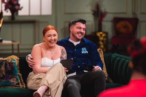 Luke Worley and his wife laughing on a couch.