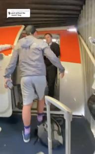 A passenger is being prevented from boarding a plane by airport staff.