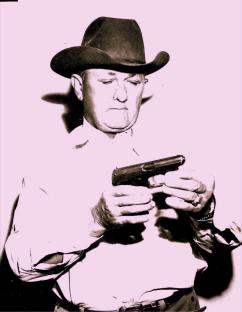 Sheriff Jess Slaughter examining a handgun.