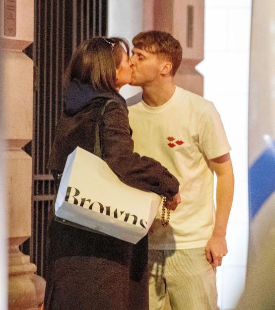Jamie Borthwick and Georgina Shave kissing outdoors, Georgina holding a "Browns" shopping bag.
