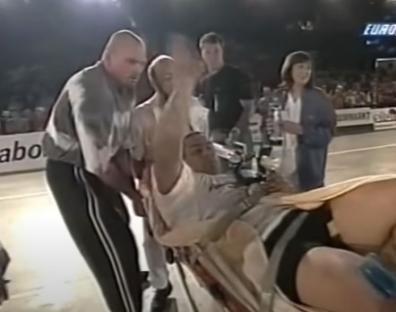 Strongman being carried off on a stretcher.