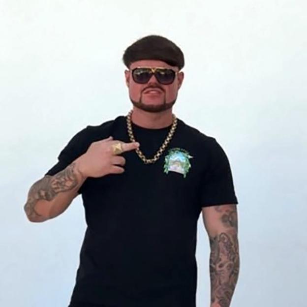 Jack Kay, the "Ibiza Final Boss," pointing to his gold chain.