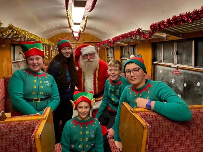Santa and five elves on a Christmas train.