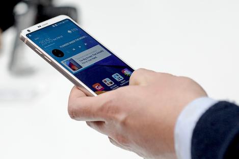 Person holding and using an LG G6 smartphone.