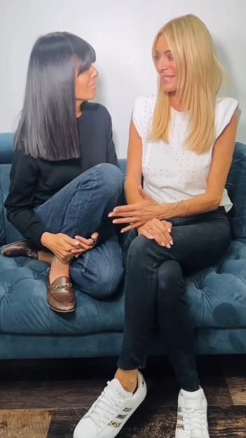 Tess Daly and Claudia Winkleman sitting on a blue couch.