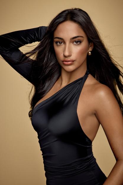 Portrait of a woman in a black one-shoulder dress.