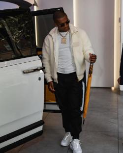 Conor Benn exiting a white car, holding an umbrella.