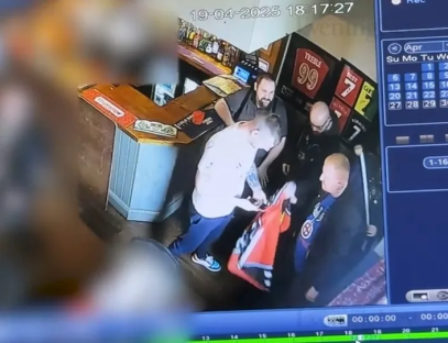 Security camera footage of men in a pub examining a jersey.
