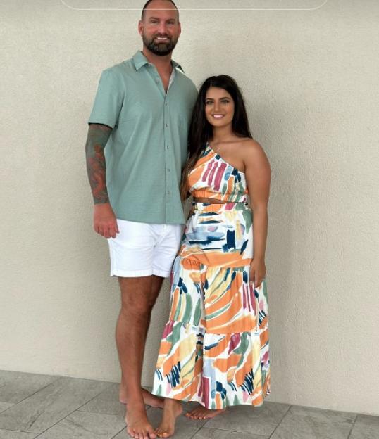 Woman and man standing together and smiling.