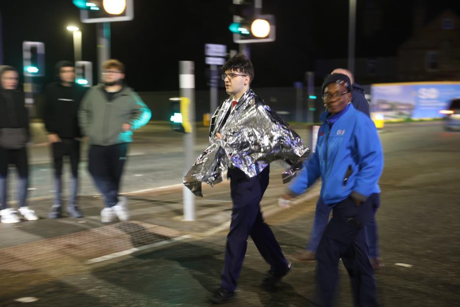 An LNER train staff member wearing a foil blanket after multiple people were stabbed on a train in Huntingdon.