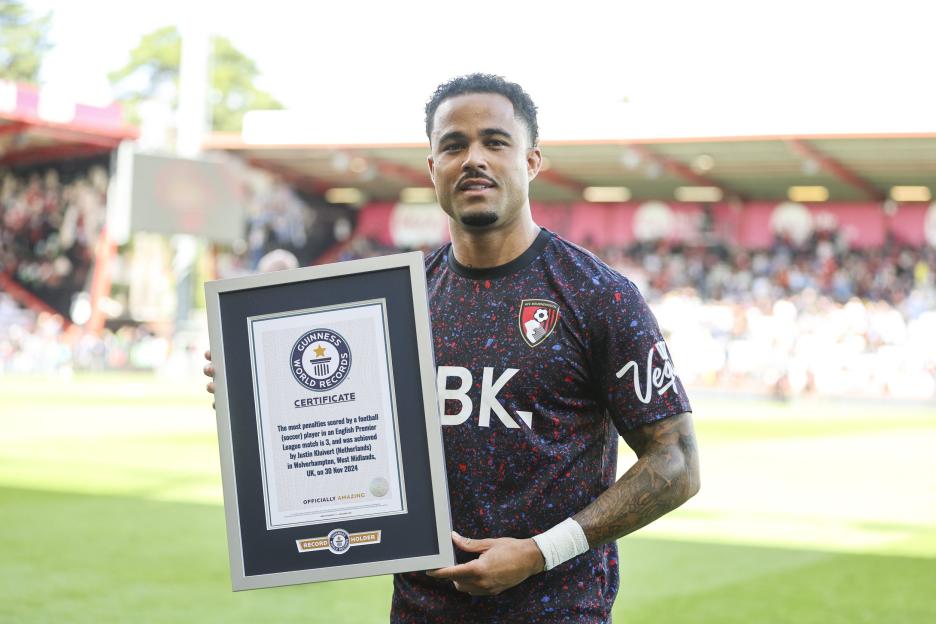 Justin Kluivert holding his Guinness World Record certificate for scoring three penalties in a single Premier League match.