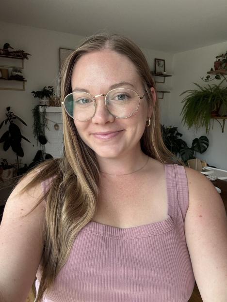 Kassadi Gabriel, a smiling woman with long blonde hair and glasses, wearing a pink top.