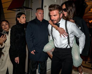 David Beckham carrying Victoria Beckham on his back.