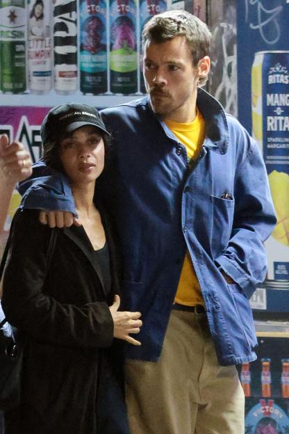 Harry Styles and Zoë Kravitz walking arm in arm.