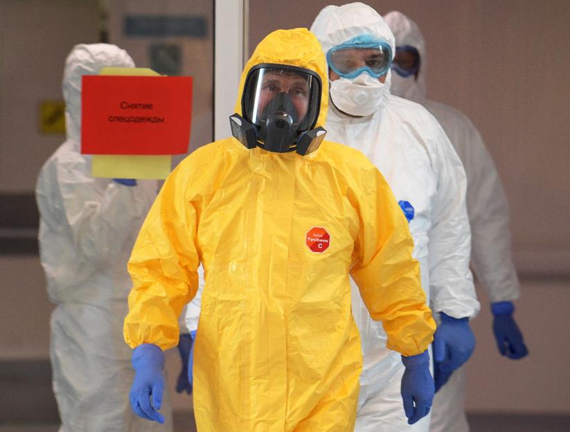 Person in yellow protective suit visiting a hospital.