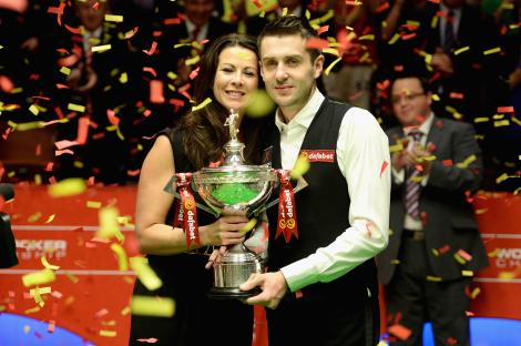 Mark Selby and his wife holding a trophy amidst confetti.