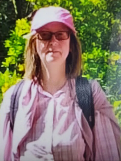 Photo of a woman wearing glasses and a pink hat.