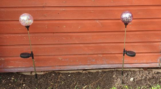 Two solar-powered garden lights with speckled glass globes.