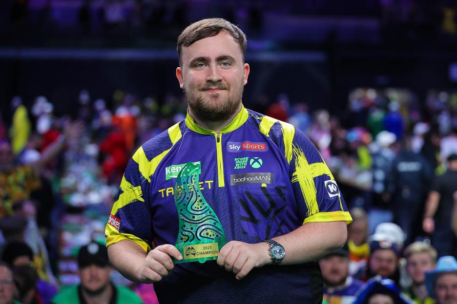 Luke Littler holding the Australian Darts Masters trophy.