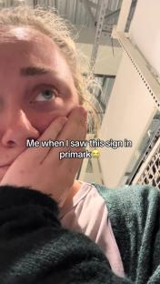Close-up of a person reacting sadly to a sign in Primark.