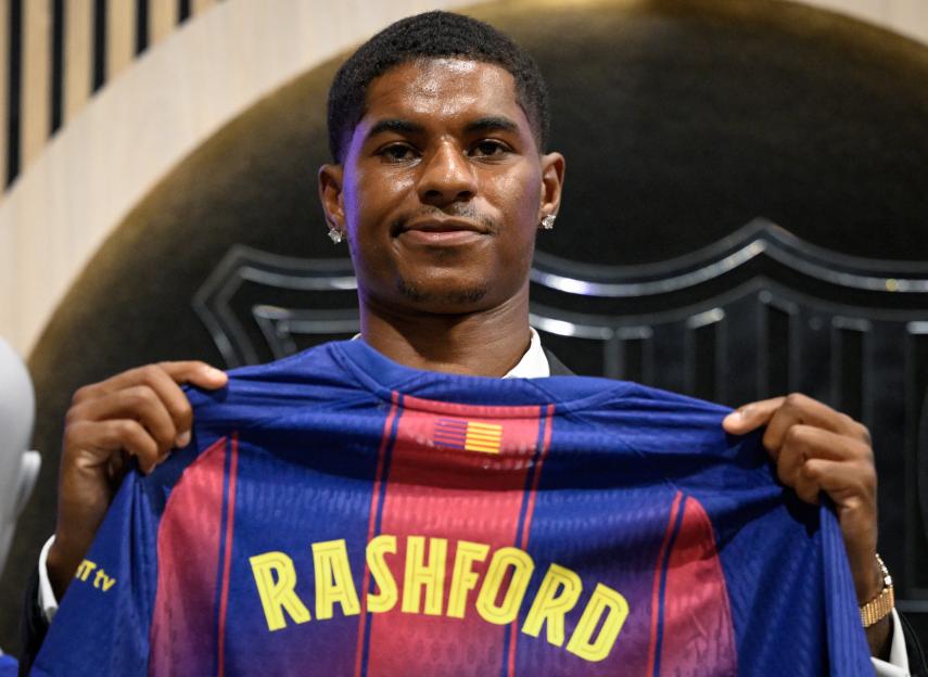 Marcus Rashford holding up his new Barcelona jersey.