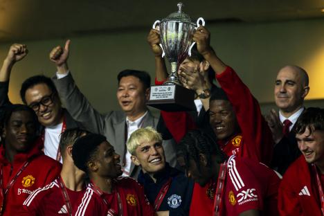 Manchester United players celebrating with a trophy.