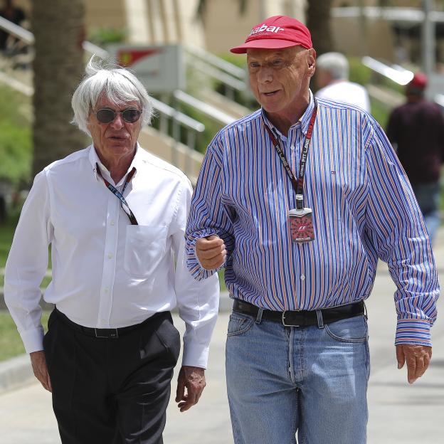 Formula One boss Bernie Ecclestone and former driver Niki Lauda walk in the paddock.