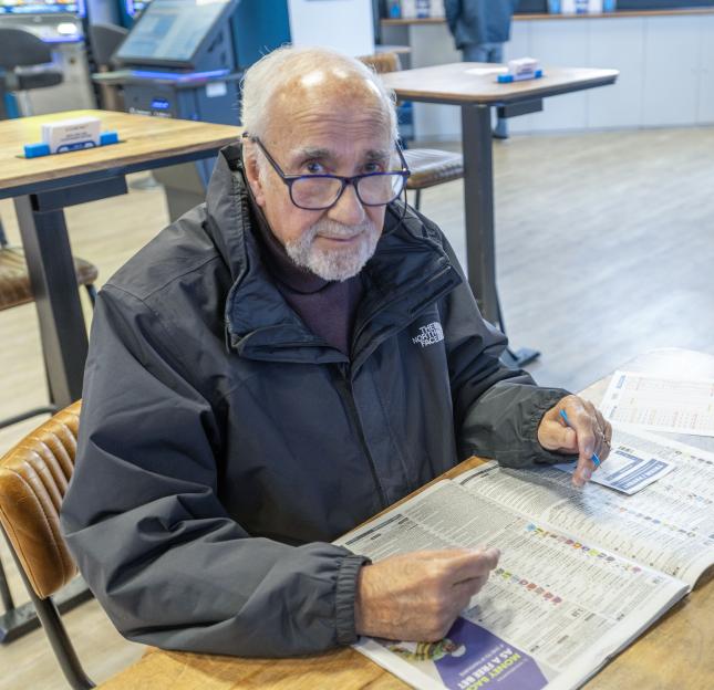 Len Atkins, 83, in a black jacket and glasses, completing a betting slip at a Coral branch in Clacton-on-Sea.