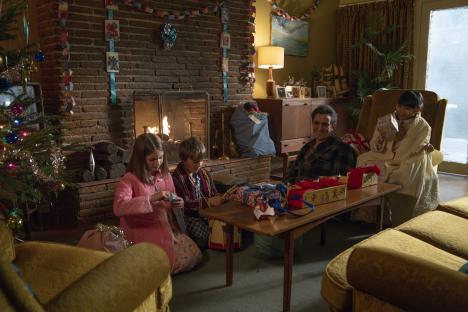 Scene from Call the Midwife Christmas special: a family opens presents by a fireplace.
